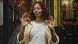 © Krakenimages.com - Young woman smiling makes ok sign with both hands in ornate church interior; faith approval joy hope.