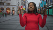 © Krakenimages.com - Woman in red sweater shrugs with hands raised, flipping fingers near face and pursing lips on a busy pedestrian street lined with shops and neon signs; indifference dismissal.