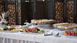 © Filirovska - Elegant dessert buffet table featuring platters of fresh fruit and assorted sliced cakes at an event