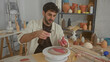 © Krakenimages.com - Man spraying a bottle onto a lump of clay while holding it in his hands on a turntable in a studio; craft practice serenity.