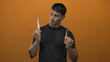 © Krakenimages.com - Man holds white electric toothbrush and bamboo toothbrush in modern studio; choice comparison indecision.
