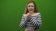 © Krakenimages.com - Woman with clasped hands and worried expression wearing striped off shoulder crop top, redhead against green studio screen, pleading with clenched fingers; anxiety.