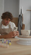 © Krakenimages.com - Man in studio holding smartphone and paintbrush at a pottery wheel with ceramic mug, tapping screen and inspecting glaze; quiet concentration.