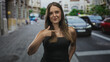 © Krakenimages.com - Woman points finger to chest, bare shoulders visible in busy street with cars, buildings and a crosswalk; confidence adventure.