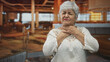 © Krakenimages.com - Woman touching neck with both hands in airport lounge, eyes closed and grimacing; throat pain discomfort.