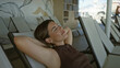 © Krakenimages.com - Woman reclining on deck chair with arms behind head and armpit visible in a building; quiet calm rest.