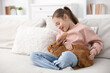 © New Africa - Girl with cute bunny on sofa at home. Space for text
