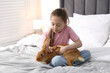 © New Africa - Girl with cute bunny on bed at home. Space for text