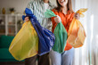 © Miljan Živković - Couple holding colorful plastic bags for waste sorting and recycling