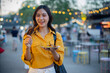 © Laingzaifa - An Asian woman is strolling through a night market, enjoying traditional street food, colorful lanterns, and smiling at the bustling city stalls. It's a vibrant atmosphere and a wonderful cultural