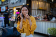 © Laingzaifa - Asian women enjoy delicious street food at night markets, smiling throughout their vacation, exploring the city's culture, vibrant lights, and fun-filled adventures.