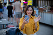 © Laingzaifa - Asian women enjoy delicious street food at night markets, smiling throughout their vacation, exploring the city's culture, vibrant lights, and fun-filled adventures.