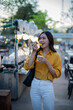 © Laingzaifa - Asian women enjoy delicious street food at night markets, smiling throughout their vacation, exploring the city's culture, vibrant lights, and fun-filled adventures.