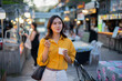 © Laingzaifa - Asian women enjoy delicious street food at night markets, smiling throughout their vacation, exploring the city's culture, vibrant lights, and fun-filled adventures.