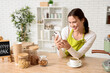 © Pixel-Shot - Happy young female barista with mobile phone in cafe