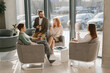 © dsheremeta - Business colleagues having informal meeting in modern office lobby