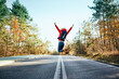 © Westend61 - Cheerful woman jumping on an empty road during backpacking trip