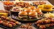 © arif - High angle view of a rich tailgate buffet featuring mini burgers, chicken skewers, grilled corn, and pretzels.