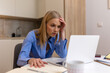 © Graphicroyalty - Stressed woman having headache or problem while working on laptop. Frustrated female freelancer touching forehead looking at computer screen in kitchen. Business failure or technical issue concept.
