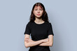 © Valerii Honcharuk - Portrait of smiling confident teenage girl with crossed arms on gray background