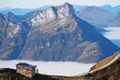 © Stephanie - Vue panoramique des Alpes suisses depuis le Fronalpstock, canton de Schwyz, avec chalet en bois, sommets et mer de nuages