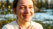 © YURY - Emotional woman smiling while standing outdoors in spring sunlight