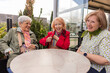© ADDICTIVE STOCK - Senior women enjoying outdoor cafe gathering