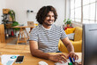 © Xavier Lorenzo - Young Indian man freelancer working on desktop computer at home office desk. Remote professional typing on keyboard and smiling while focusing on online project. Business and working at home concept.