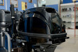 © bo.kvk - A boat motor with a tiller, displayed in a watercraft store.