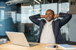 © Liubomir - Mature businessman finding comfort and peace, leaning back in his chair with hands behind head and eyes closed, achieving success and satisfaction at work in a modern corporate office setting