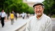 © pvl0707 - Elderly japanese man smiles while standing outdoors under trees on a summer day in a park wearing glasses and a cap
