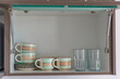 © Kai Grim - Kitchen cabinet with cups glasses and saucers inside