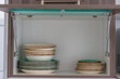 © Kai Grim - Kitchen cabinet with stacked plates and bowls inside