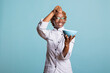 © DC Studio - African american professional cook happily sprinkling pinch of salt into bowl to enhance flavor. Happy female chef adds final touches to freshly prepared meal, showing joy and passion for cooking.