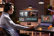 © DC Studio - Cheerful freelancer editing film soundtrack at home and comparing videos on multiple devices on desk. Asian filmmaker reviewing visual effects, sound and color grading during post production session.