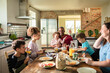 © Marko Geber - Smiling parents and kids eating breakfast together in a home kitchen
