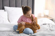 © New Africa - Girl with cute bunny on bed at home