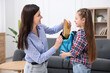© New Africa - Mother and daughter packing backpack for school at home