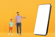 © New Africa - Family looking at big smartphone with blank screen on orange background. Father pointing at device near his son
