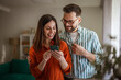 © Miljan Živković - Couple looking at smart phone together sharing online content