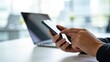 © Charlotte - Close up of hands using smartphone with laptop on desk,online communication and mobile business concept,digital marketing and remote work lifestyle