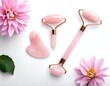 © Zg - A pink jade roller and gua sha set with flowers on white