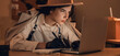 © Pixel-Shot - Female spy with laptop writing on notebook in office at night
