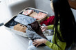 © Charlie's - Woman packing suitcase on bed for a new journey packing list for travel planning, preparing vacation Book Now Traveling Transportation