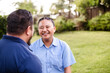 © NZstockphoto - Happy Samoan teenage girl having conversation with dad outdoors