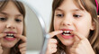 © designer rofiqul - Young girl examining her teeth in a mirror close up child