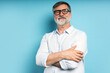 © opolja - Bearded middle-aged man wearing glasses posing over blue studio background