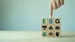 © sajjad - Hand pointing to the S on ESG wooden blocks with icons for environment social governance on a light table against a calm background