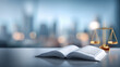 © Анна Терелюк - Law book on desk with scale. A law book is open on a table next to a balance scale. The setting is an office with a city view in the background.