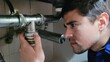 © NoblePix - Man inspecting plumbing under sink, focusing on a pipe connection for potential leaks